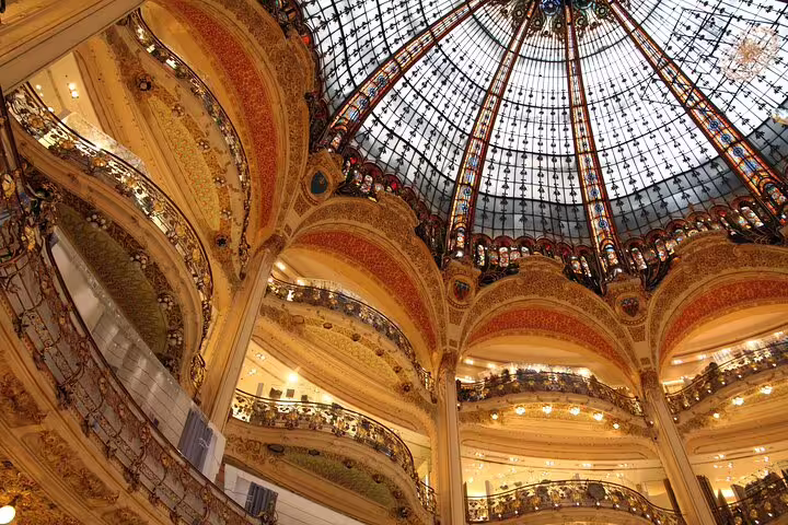Stunning view of the ornate dome and opulent balconies inside a historic Parisian shopping gallery, showcasing architectural grandeur.