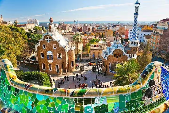 Vibrant view of Park Güell in Barcelona with colorful mosaics and iconic architecture on a sunny day.