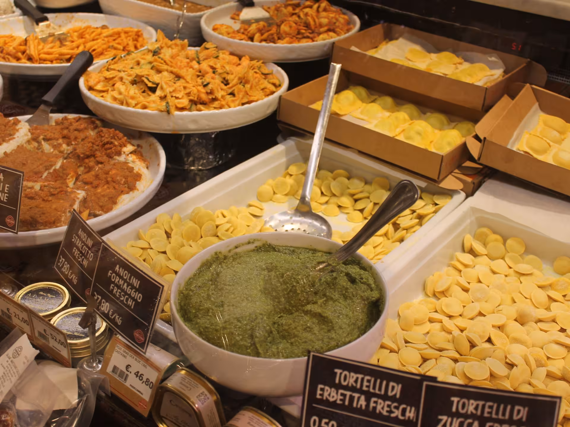 Assorted fresh pasta and pesto on display in Parma, Italy, highlighting authentic Italian culinary delights.