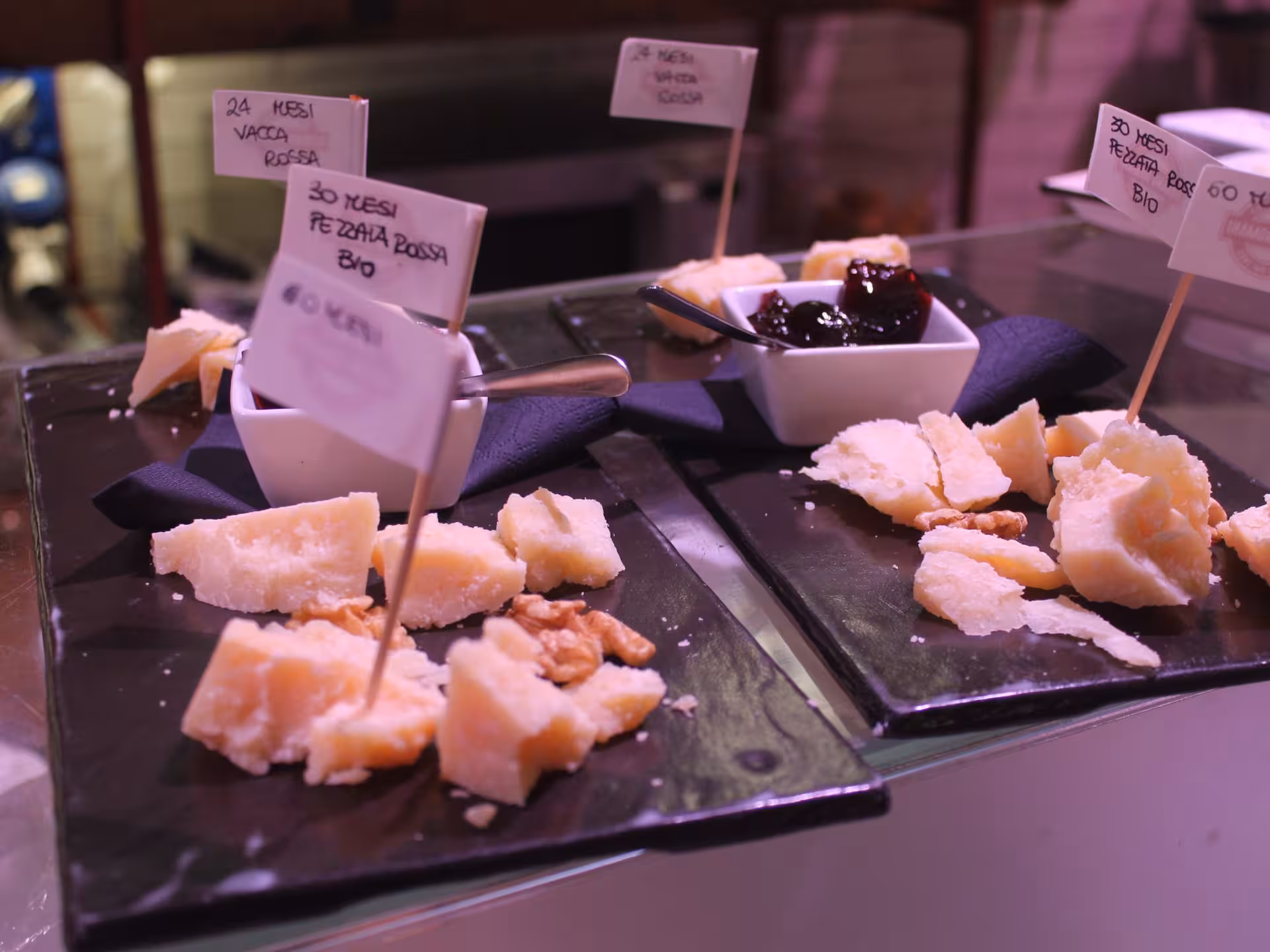 Delicious Parmigiano-Reggiano cheese tasting with walnuts and jam, highlighting Parma's culinary delights.