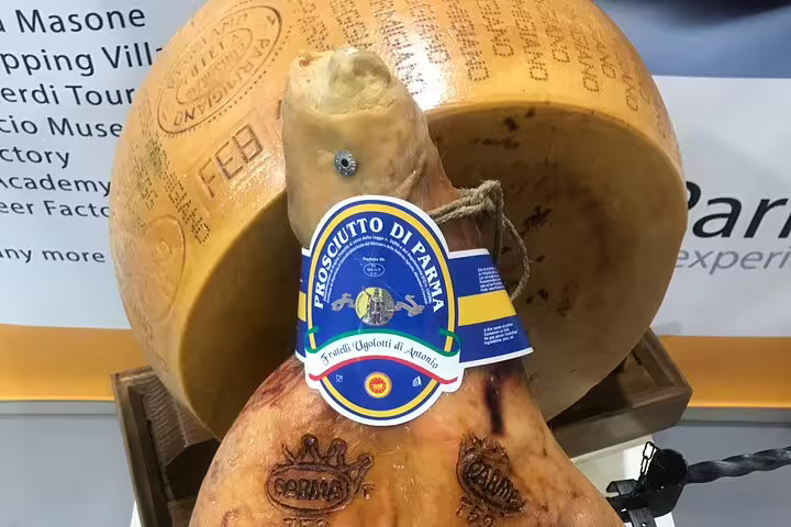Wheel of Parmigiano-Reggiano and Prosciutto di Parma on display, showcasing authentic Italian culinary heritage.