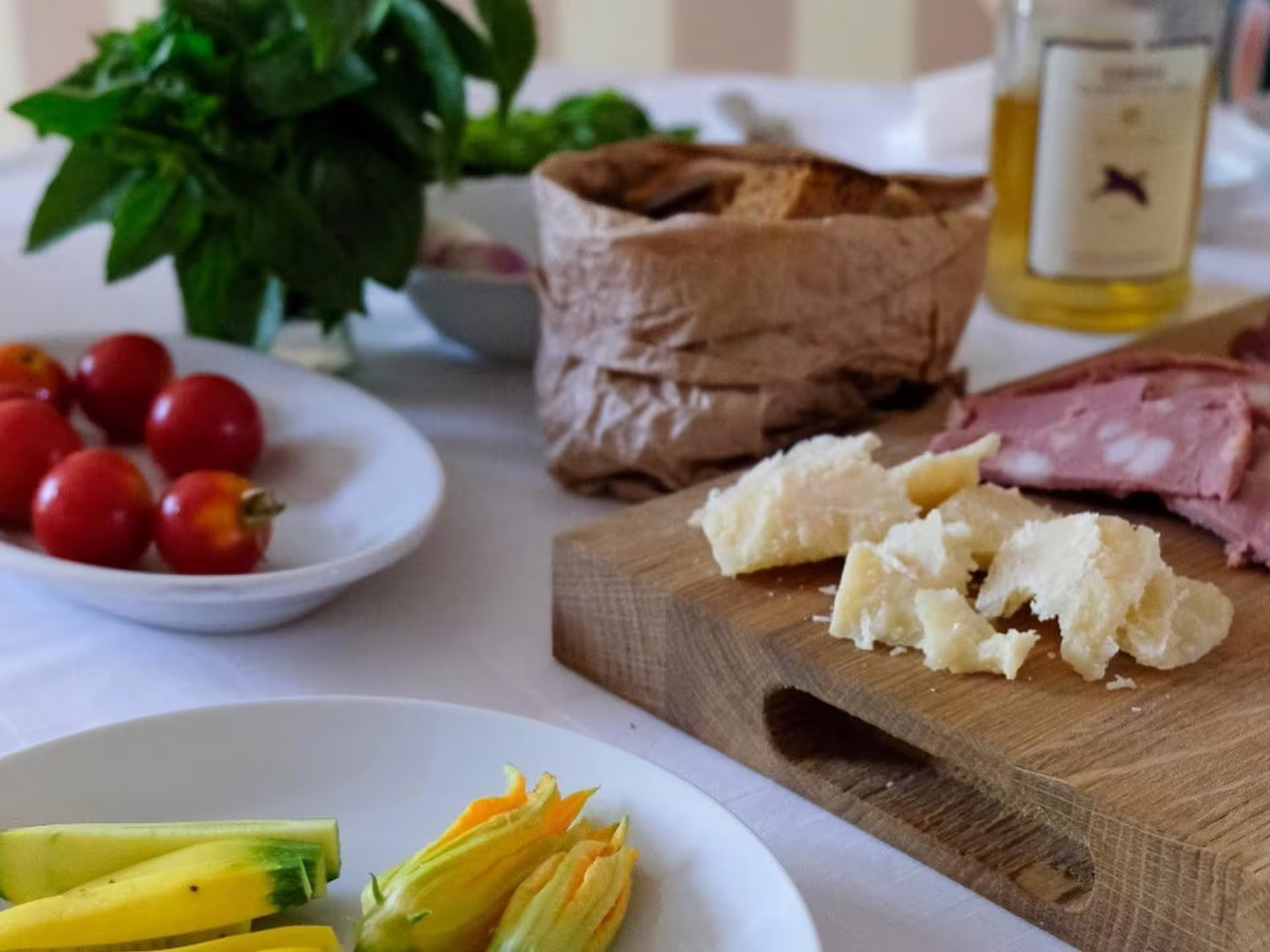 Parmigiano Reggiano tasting near Modena with Parmesan chunks, cured meats, bread, basil and local wine