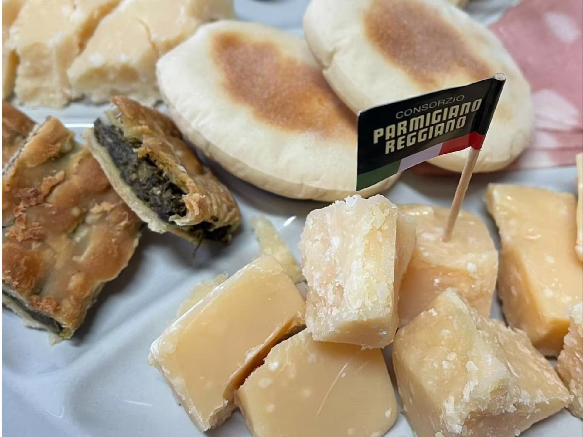 Parmigiano Reggiano tasting plate with aged Parmesan chunks and local snacks on Modena factory tour