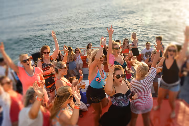 Excited crowd dancing and celebrating on a lively sunset boat party tour in Albufeira Portugal