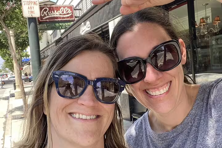 Two smiling women taking a selfie outside Russell's restaurant in Pasadena during a walking tour