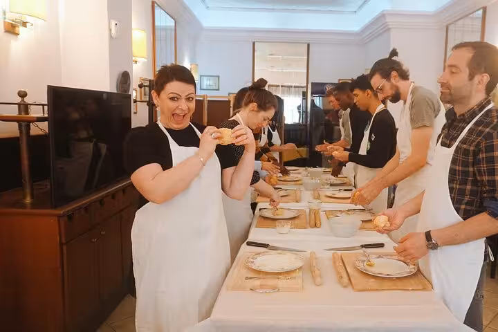 Excited participants making pasta during a cooking class in Rome's Piazza Navona, showcasing Italian culinary traditions.