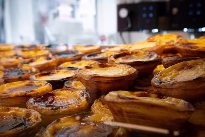 Freshly baked pastel de nata pastries on display in a Porto bakery during a food tour.