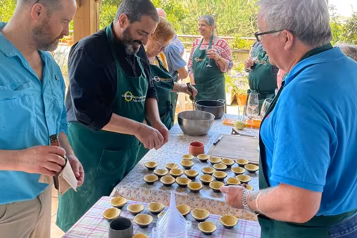 Group of enthusiasts preparing Pastel De Nata on a terrace, guided by an expert, while enjoying the vibrant atmosphere.
