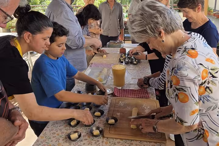 Participants learn to make Pastel De Nata in a hands-on workshop on a sunny terrace, enhancing their culinary skills.