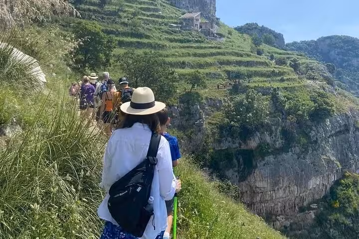 Group of hikers exploring lush terraced landscapes on the Path of the Gods, a popular Amalfi Coast trail.