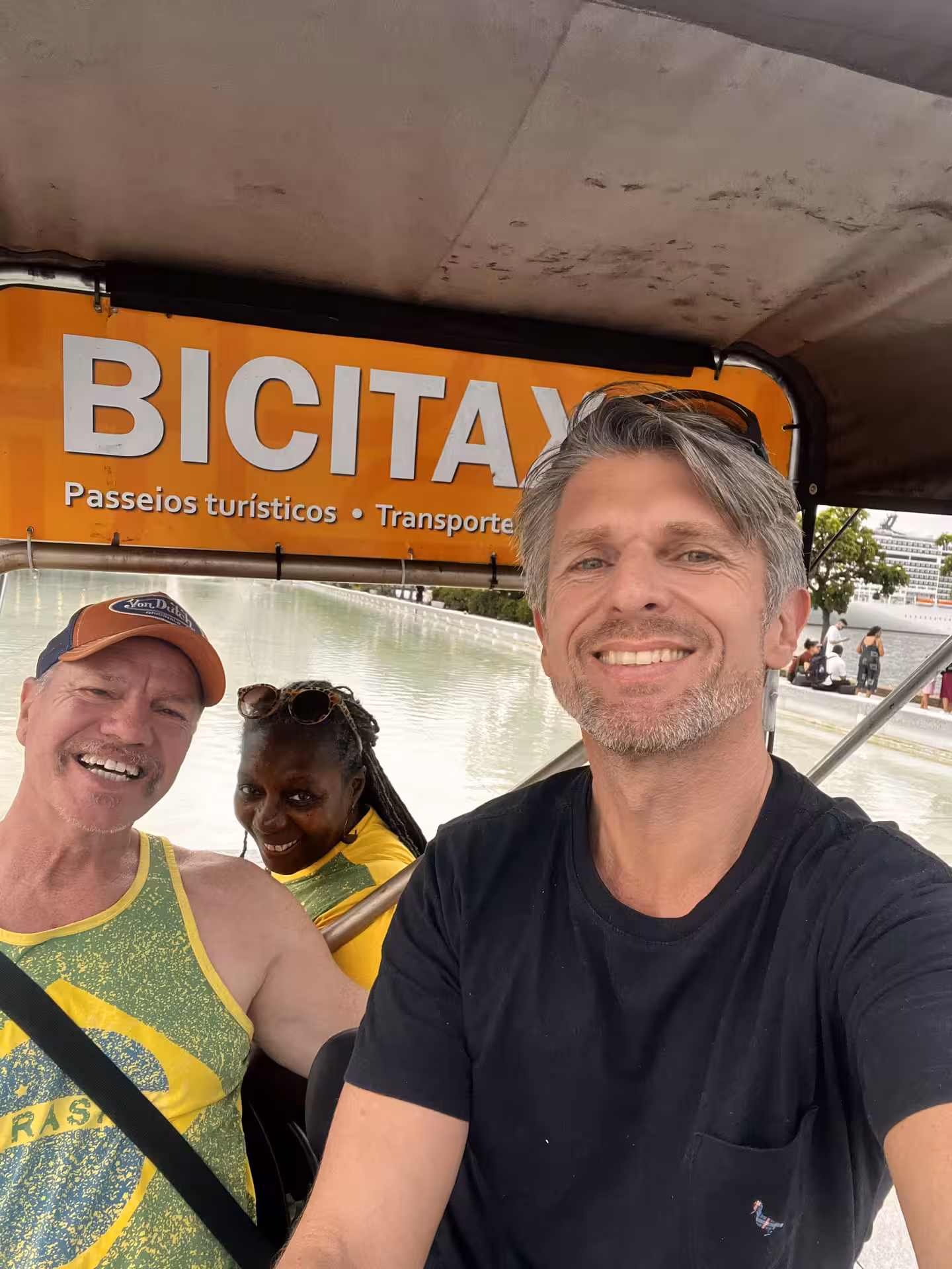 Smiling travelers in a pedicab during a Rio de Janeiro historical city centre tour, near Cinelândia square