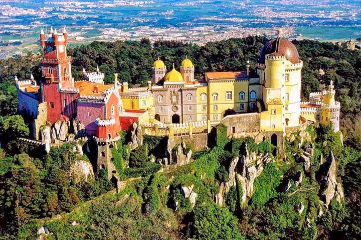 Majestic Pena National Palace in Sintra, showcasing vibrant architecture amidst lush greenery and hilltop views.