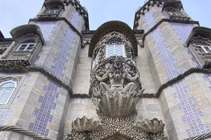 Ornate facade with mythological sculpture at Pena Palace, featured in the Magic Sintra & Cascais tour.