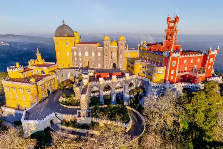 Aerial view of colorful Pena Palace in Sintra, showcasing stunning architecture on a full-day tour with tickets included.