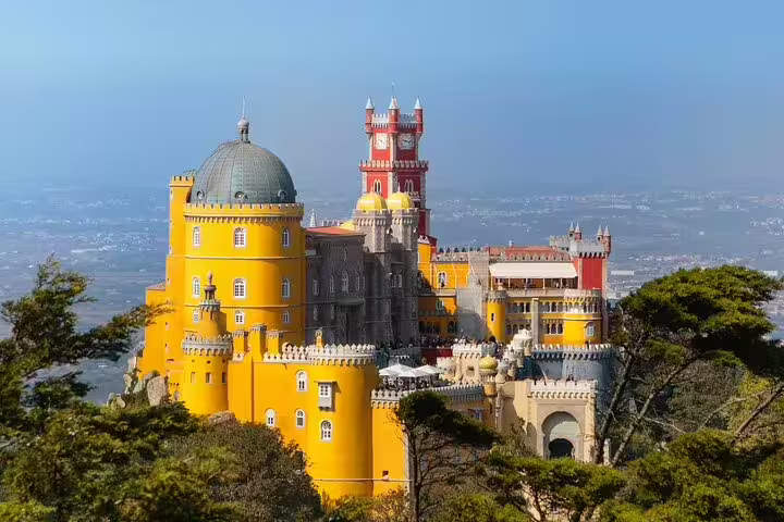 Colorful Pena Palace in Sintra, Portugal, surrounded by lush greenery, featured in a private customizable full-day tour.