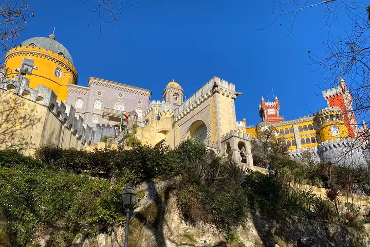 Majestic Pena Palace in Sintra, showcasing its colorful architecture against a clear blue sky.