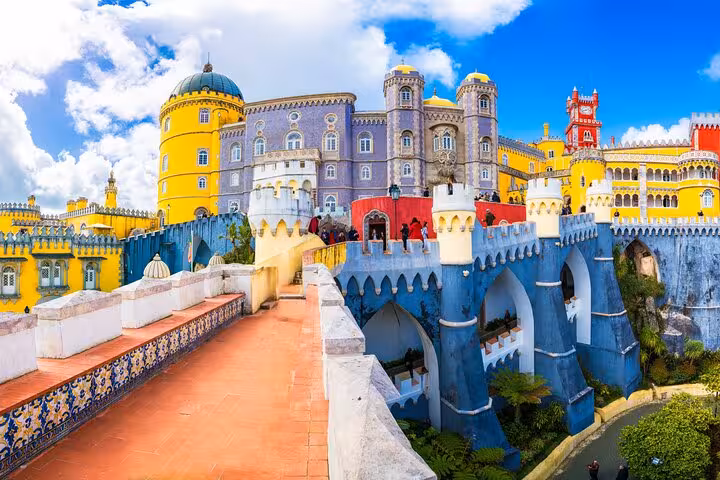 Vibrant exterior of Pena Palace in Sintra with colorful towers and stunning architectural details.