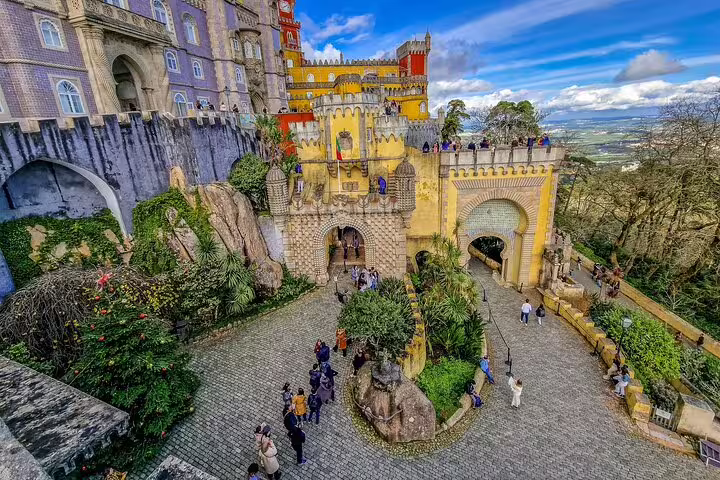 Vibrant view of Pena Palace in Sintra during a full-day private tour, showcasing its colorful architecture and scenic surroundings.