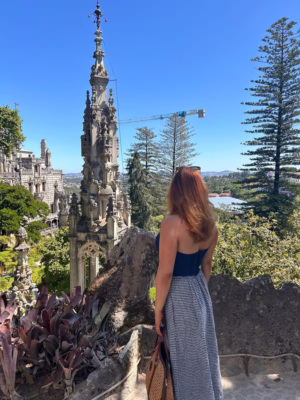 Woman admiring the stunning architecture and lush greenery of Pena Palace in Sintra, perfect for a half-day tour.