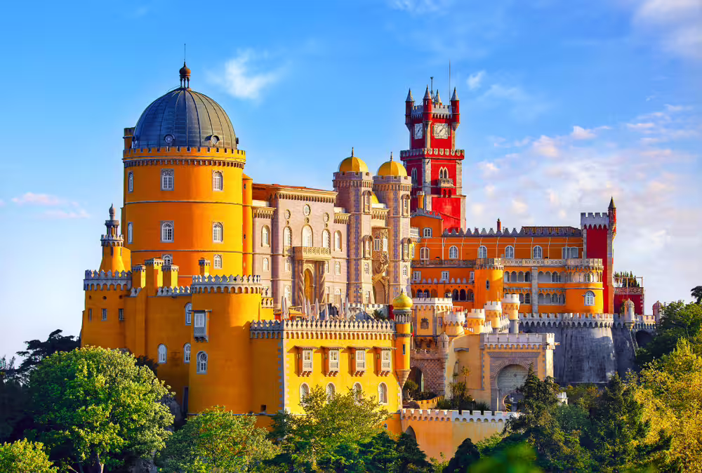 Colorful Pena Palace in Sintra, Portugal, with vibrant towers and lush greenery, a highlight of the Lisbon day trip tour.