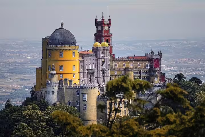 Majestic Pena Palace in Sintra surrounded by lush forest, a must-see on guided tours from Lisbon to Cascais.