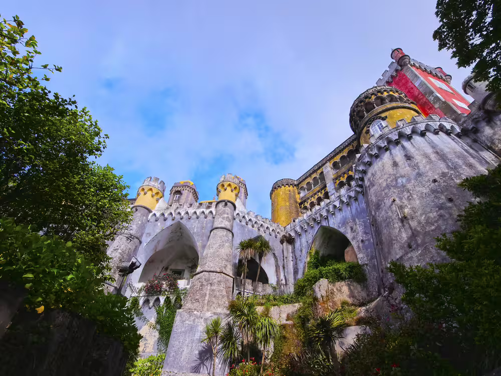 Colorful view of Pena Palace in Sintra, Portugal, surrounded by lush greenery, perfect for a Lisbon shore excursion tour.