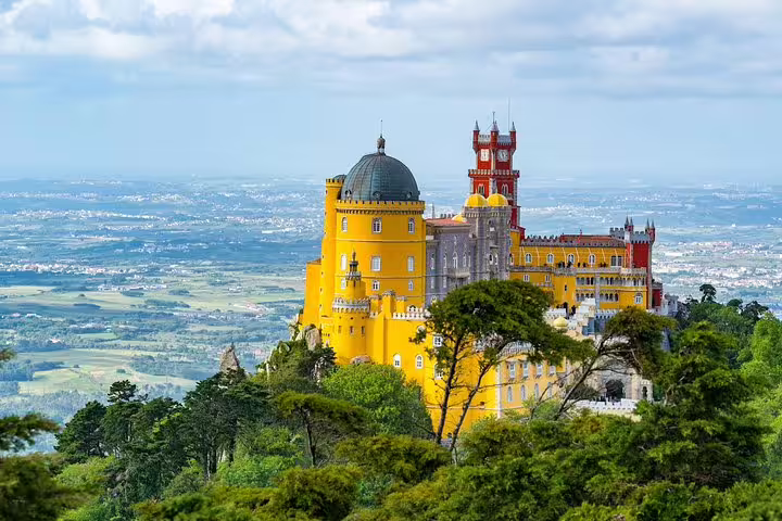 Scenic view of Pena Palace in Sintra, Portugal, showcasing vibrant architecture and lush greenery on a 7-day tour.