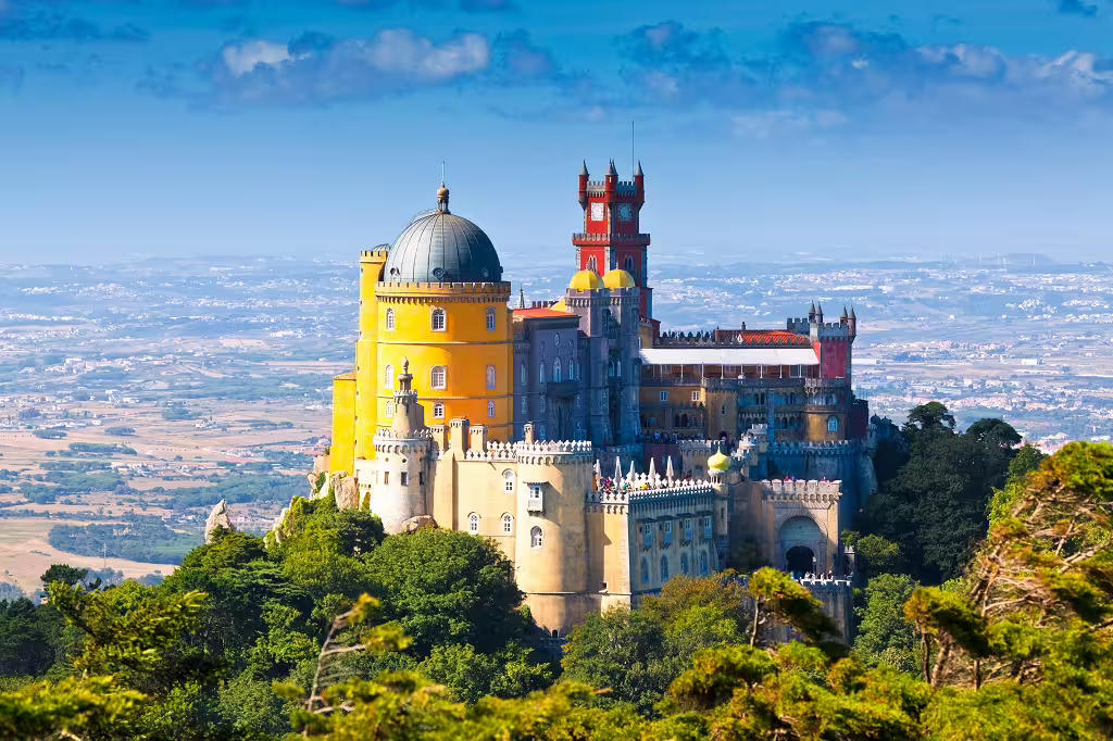 Colorful Pena Palace in Sintra, Portugal, surrounded by lush greenery with panoramic views, perfect for cultural tours.