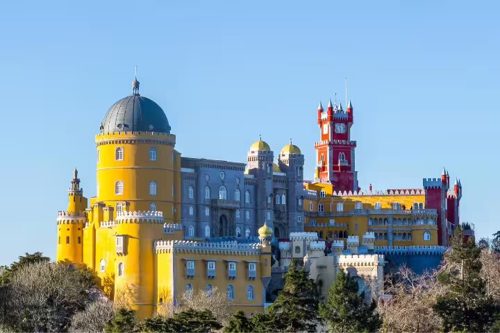 Vibrant view of the colorful Pena Palace in Sintra, Portugal, showcasing its unique architecture on a clear day.