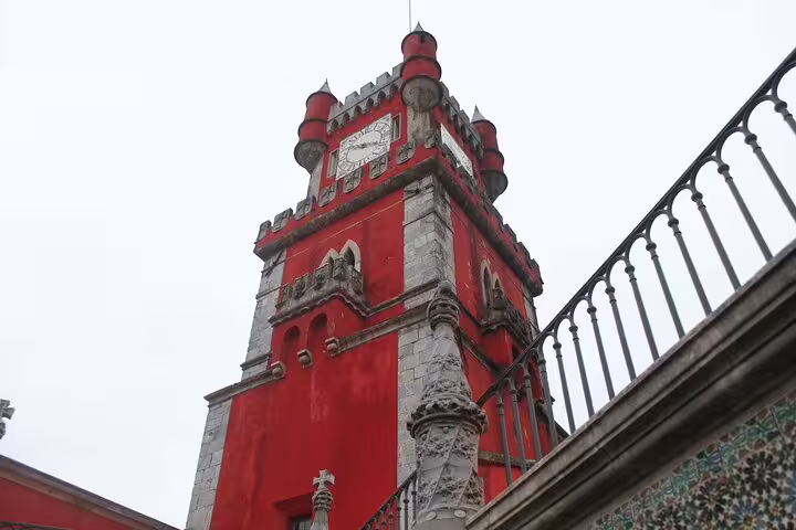 Vibrant red tower of Pena Palace in Sintra, Portugal, showcasing Gothic architecture on a day trip from Lisbon with scenic views.