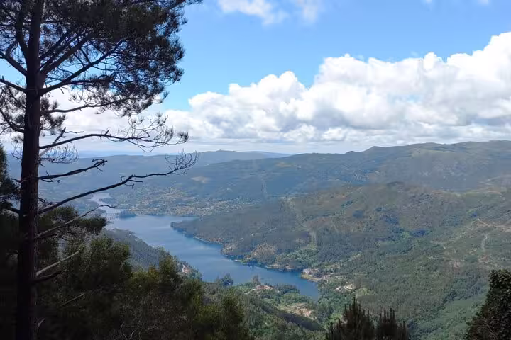 Stunning aerial view of a winding river and lush hills in Peneda-Gerês National Park under a clear blue sky.