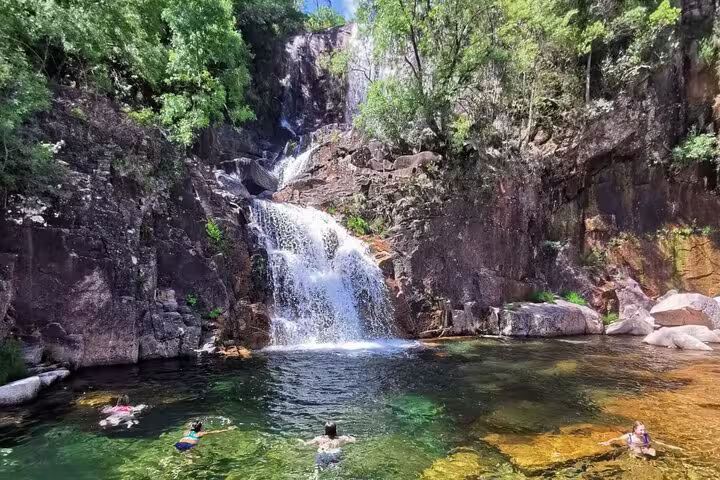 Visitors swimming near a stunning waterfall in Peneda Geres National Park during a private tour.