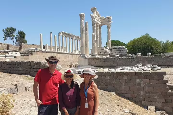 Tourists exploring the ancient ruins of Pergamon with iconic columns under a clear blue sky on the Asceplion tour.