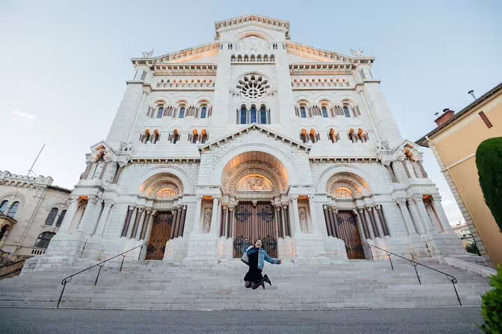 A person joyfully posing in front of a grand cathedral during a personal travel photography tour in Nice.