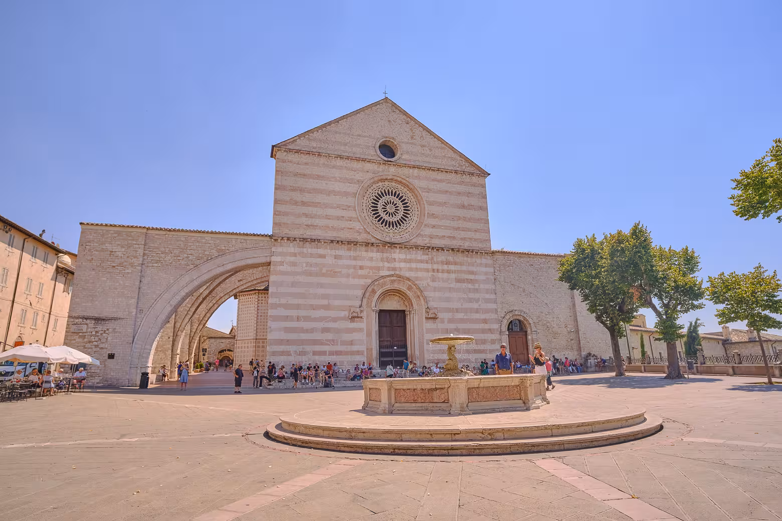 Tourists gather near the historic Basilica of Santa Chiara in Assisi, a key highlight on the Heart of Umbria tour.