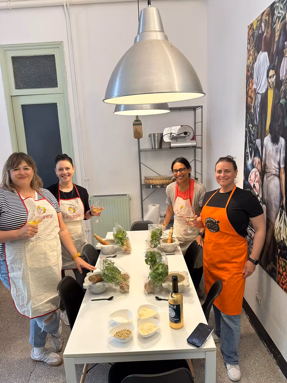 Group of participants enjoying a pesto-making class with fresh ingredients in a cozy Italian kitchen setting.