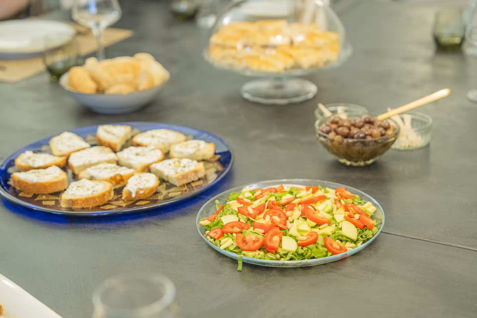 Italian antipasti featuring bruschetta, fresh salad, and olives on a table for a Portofino and Cinque Terre pesto tour.