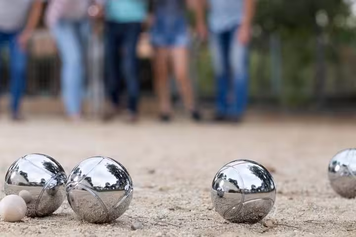 Close-up of shiny petanque boules on gravel during a Marseille game, authentic French boules tour experience