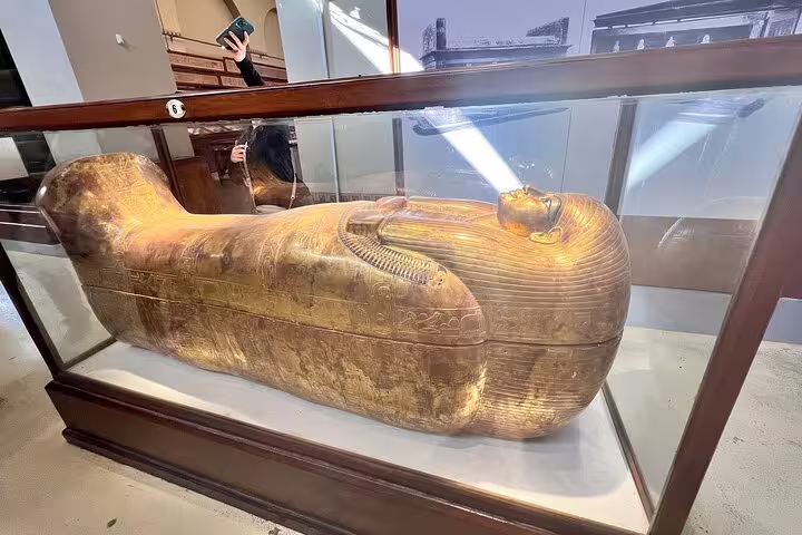 Golden pharaoh sarcophagus display in Cairo Museum on Giza Pyramids and Cairo day trip by plane from Sharm El Sheikh