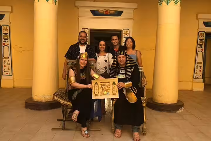 Visitors in pharaoh costumes at Pharaonic Village Cairo private tour, posing with a souvenir papyrus