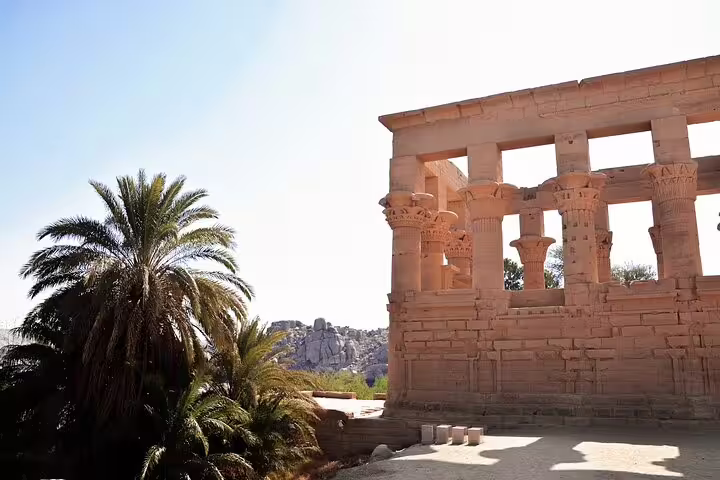 Philae Temple columns with palm trees in Aswan, scenic stop on a 5 days 4 nights Nile tour package