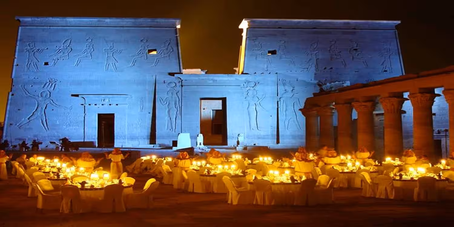 Philae Temple Sound and Light show in Aswan, Egypt, with illuminated facade and candlelit seating at night