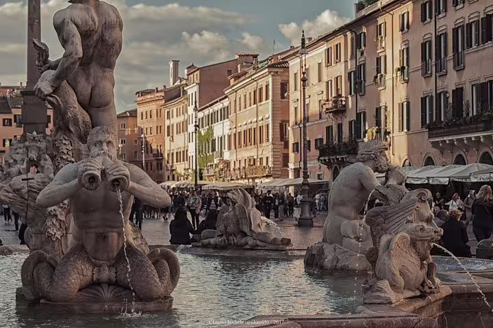 Close-up of ornate fountain statues in Piazza Navona, Rome, with bustling cafés and walking tour guests in the square