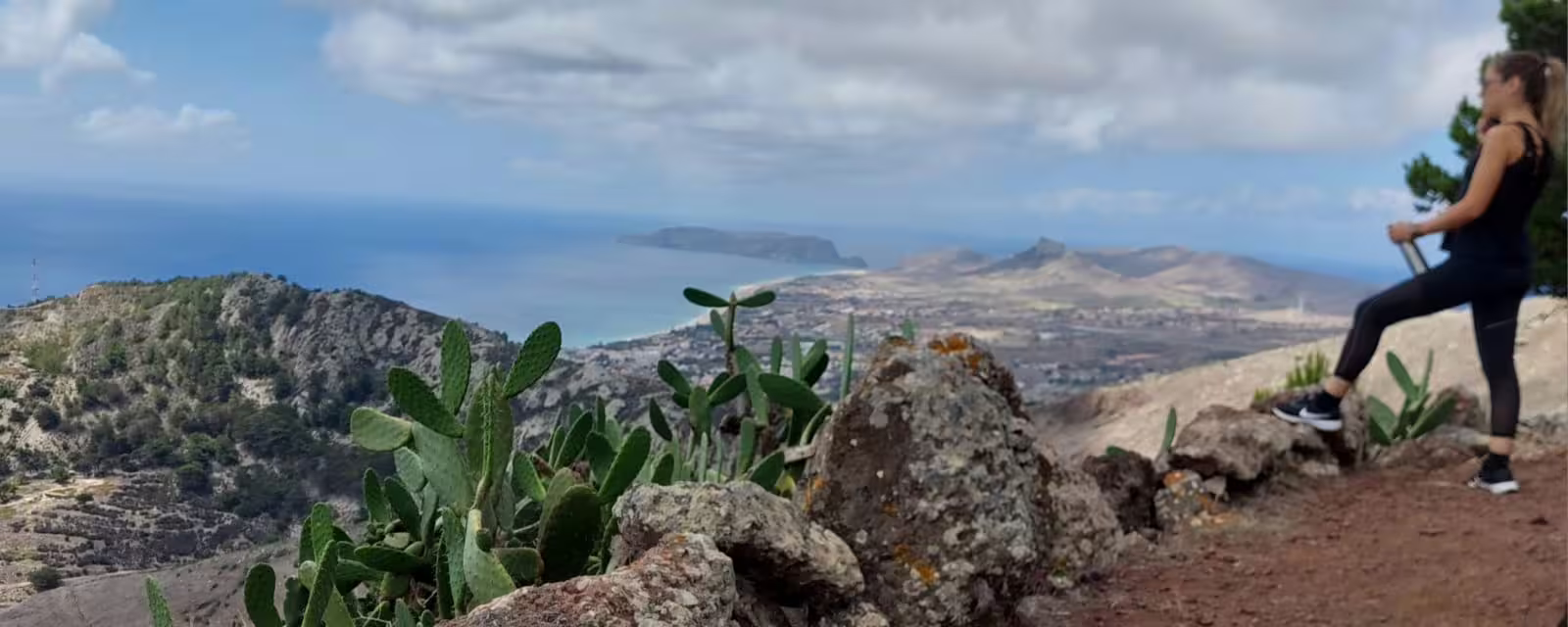 Hiker enjoying stunning ocean and mountain views on Pico do Facho Panoramic Trail, perfect for nature lovers and adventurers.