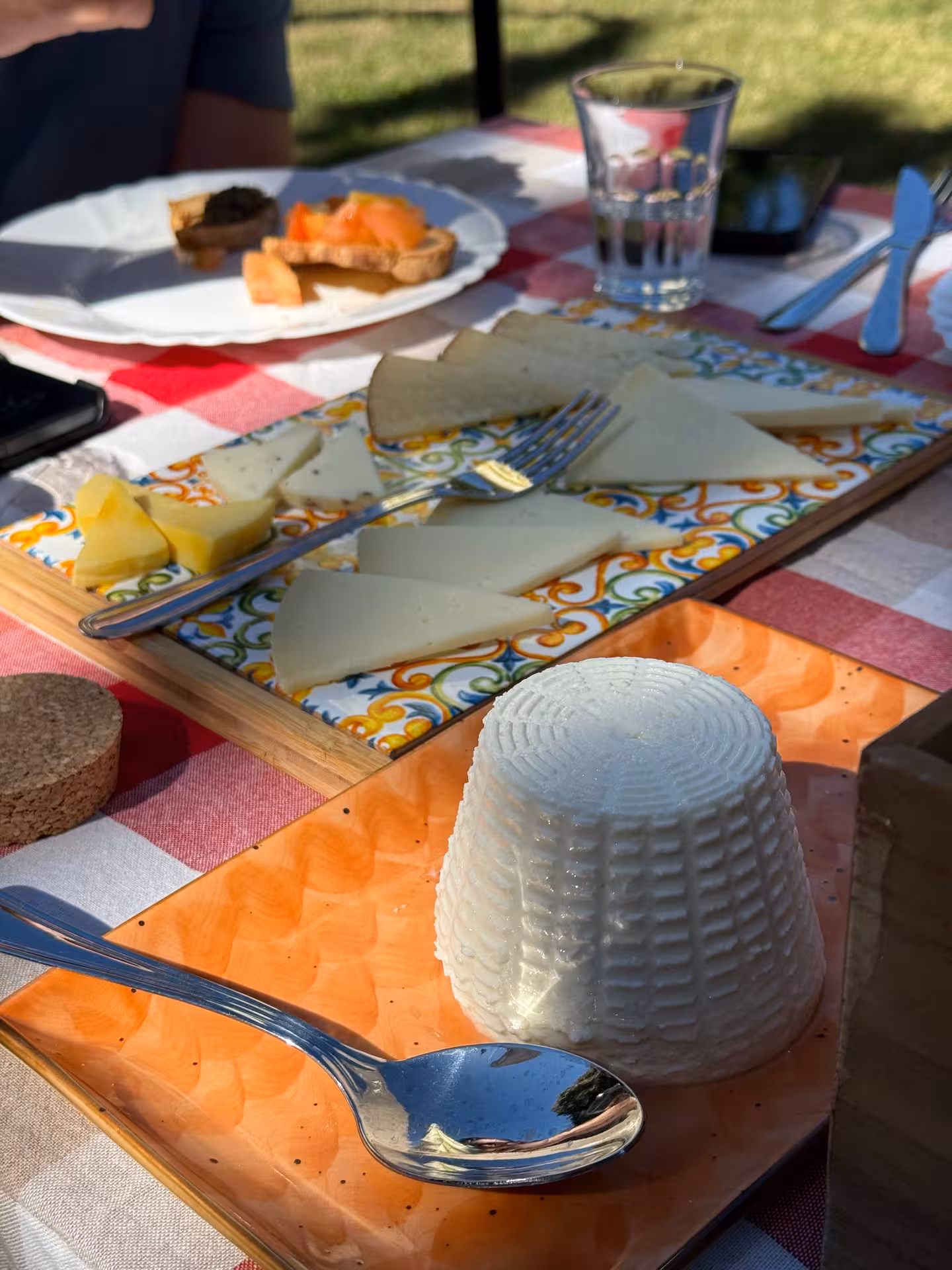A selection of local cheeses and bruschetta on a vibrant tray during a culinary tour in Pienza, Montepulciano, and Montalcino.