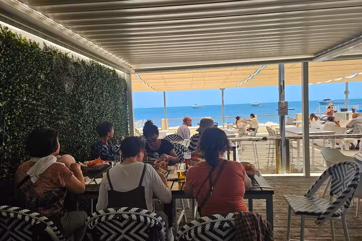 Tour group dining with ocean view at a beachfront restaurant on the Pinnacle Day Adventure Tour.