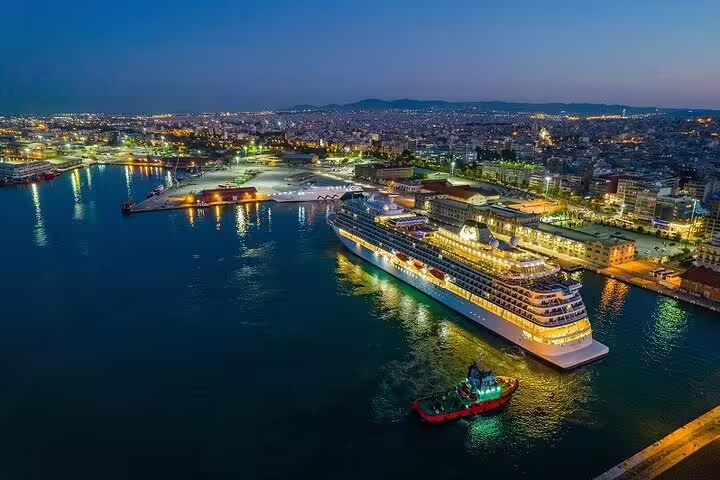 Cruise ship docked at Piraeus Port at night, private arrival transfer service to Athens city center and hotels