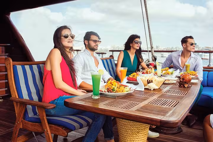 Friends enjoying lunch and drinks on deck of pirate sailing boat to Ras Mohammed and White Island, Sharm