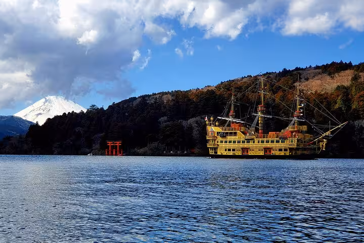 A vibrant pirate ship cruising on Lake Ashi with Mt. Fuji in the background during the Hakone tour.