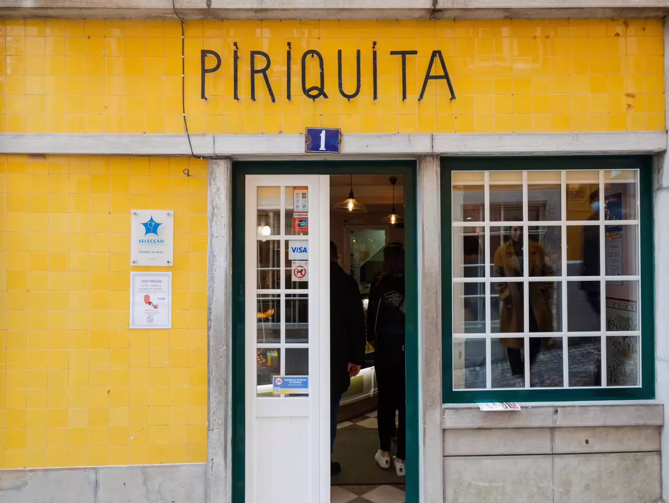 Entrance of Piriquita pastry shop in Sintra, known for its traditional Portuguese pastries and yellow-tiled facade.
